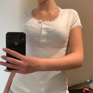 Vit trendig bas t-shirt med spets! - Denna tröjan är så otroligt söt nu när jag testar den för första gången men har ändå bestämt mig för att sälja för att spara pengar inför sommaren!🥰Super söt och har lite spets som ger en så fin komplement till tröjan!💕