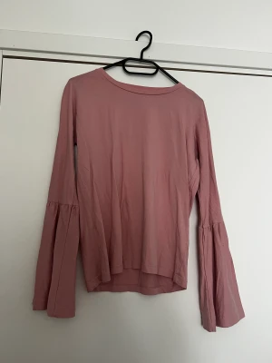 Tröja med volanger i armar - En rosa tröja/blus med vida armar 