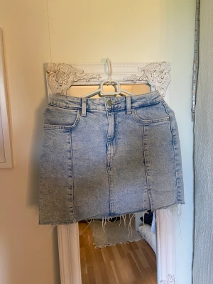 Ljusblå jeanskjol  - En så fin jeanskjol med fransning nedtill och lågmidjad passform. Sitter perfekt över rumpan och är i nytt kick. Storlek S.