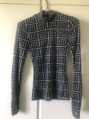 Topp - Genomskinlig topp med glitter och kort krage.