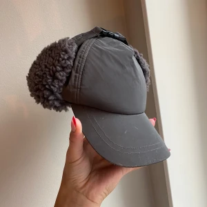 Stella McCartney keps - ”Vinterkeps” från Stella McCartney Kids, använd men jättefint skick!  Passar mig som vuxen trots att det är kids om jag knäpper upp den till större baktill! 🩷 Går att knäppa fast öronlapparna under hakan eller bara låta dem hänga ner på sidorna också