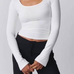 Vit långarmad topp - Säljer en vit långarmad topp med slits längst ner i armarna. Tröjan är i toppskick och i storlek M. Säljer pågrund av att den inte kommer till användning.💞