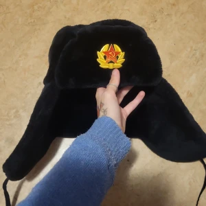 En rysk hatt med märke - Bra kvalite, typ aldrig använd, mjuk, märket kan åka av men den är lätt att sätta på men det är sällan den ramlar av, kontaka för mer bilder eller om nått annat