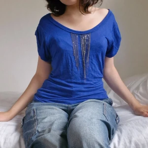 Blå blus med kedjor - Vacker, marinblå blus från New York & Company!  🌊  I fint använt skick. Kedjor framtill, korta, lösa ärmar.  Sann till storlek. Pris är självklart färhandlingsbart! 