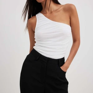 Meshtopp NAKD - Snygg topp från NAKD i stretchigt material. Den är one-shoulder. Knappt använd så i väldigt fint skick.