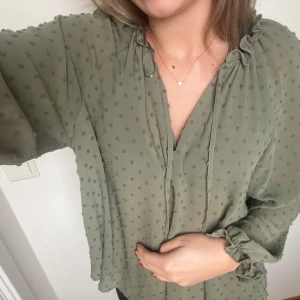 Grön blus zara - Grön blus från zara med prickar och volanger vid armslut. Strl xs men skulle säga att den är som en s