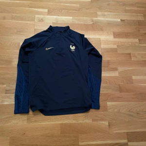 Frankrike halfzip  - En halfzip tröja från märket Nike med Frankrike som land i färgen blå