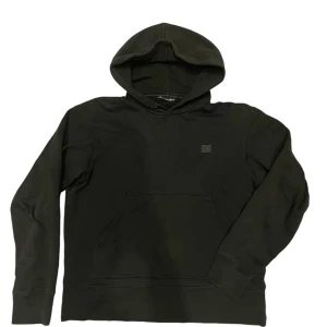 Acne Studios Hoodie - Acne Studios hoodie i svart med en patch på bröstet. Tröjan är i storlek M och är i gott skick förutom ett litet hål vid en av sömmarna. Känn dig fri att fråga om du skulle undra något mer!