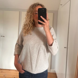 Grå tröja från COS - Säljer en stilren och bekväm grå tröja från COS. Den har trekvartsärmar och en snygg dragkedja på baksidan. Perfekt nu inför hösten och vintern. Tröjan är i bra skick🩶🍁