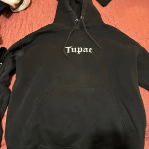 Tupac hoodie - En tupac hoodie från pull&bear!  Den är ganska använd men ändå inga skador på den bara att texten har börjat hacka (zooma in på bild 2 på texten) annars är den fin och mysig. Den är liten i storleken. Köpt länge sen för ungefär 450kr (om jag minns rä