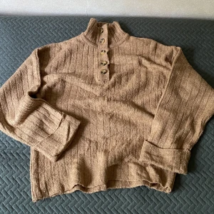 stickad tröja m knappar - stickad tröja m knappar och hög hals. strl 36 med oversize fit. 🤍bra skick, men nopprig (se bild 2 & 3). pris kan diskuteras 