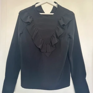 Blus  - Svart blus med volanger  Storlek 36/S Från HM 