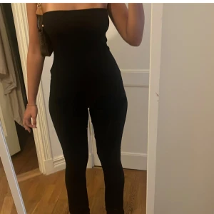 Jumpsuit  - Jumpsuit från prettylittlething, aldrig använd lappen är till och med kvar! Super skönt matrial och fin knyt detalj i ryggen. Benen är även utsvängda längst ner🖤