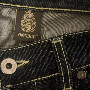 DONDUP RAW DENIM!! (Sällsynt asfett fynd) - Feta raw denim dondup jeans. Mörkblå med dondups klassiska små röda och orangea detaljer och ljusa gulaktiga sömmar. Denimen är använd och har börjat få selvage men skicket är prima! Inga defekter alls!