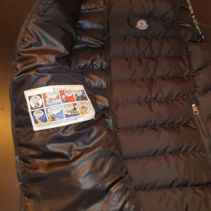 Svart Moncler Väst - En fin Moncler väst i gott skick. Inte de bästa bilderna pågrund av dåligt ljus och kamera. Den passar perfekt till vår och höst men också kyliga sommarkvällar då man vill sticka ut. Det är rätt så kallt nu så detta är ett perfekt kap för dig som vill hålla dig varm och stilig. Öppen för förhandlingar eller trade. 