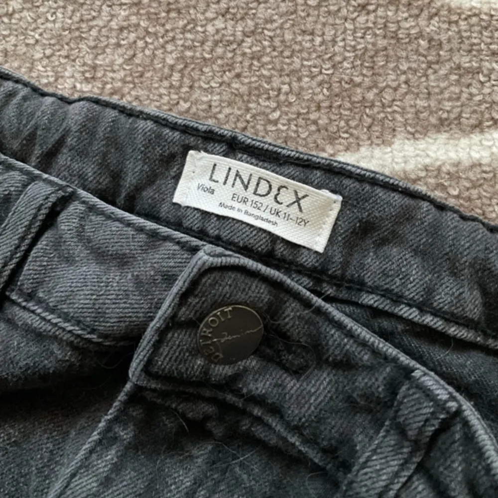 Säljer ett par svarta byxor från Lindex i storlek 152. De har en loose passform och är perfekta för både vardag och fest. Byxorna är i bra skick och har en klassisk design med knapp och dragkedja framtill.. Farkut & Housut.