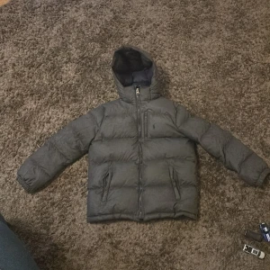 Grå Ralph lauren jacka - Jackan är i bra skick men ett litet hål på armen på sista bilden men syns knappt. Hör av dig om undra något, pris kan sänkas