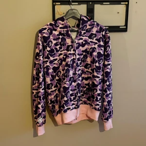 Bape Camo Shark Full Zip Pink/Purple - Denna tröja är i storlek L funkar för M. Har använt 1 gång (som ny) bekväm och skön material. 