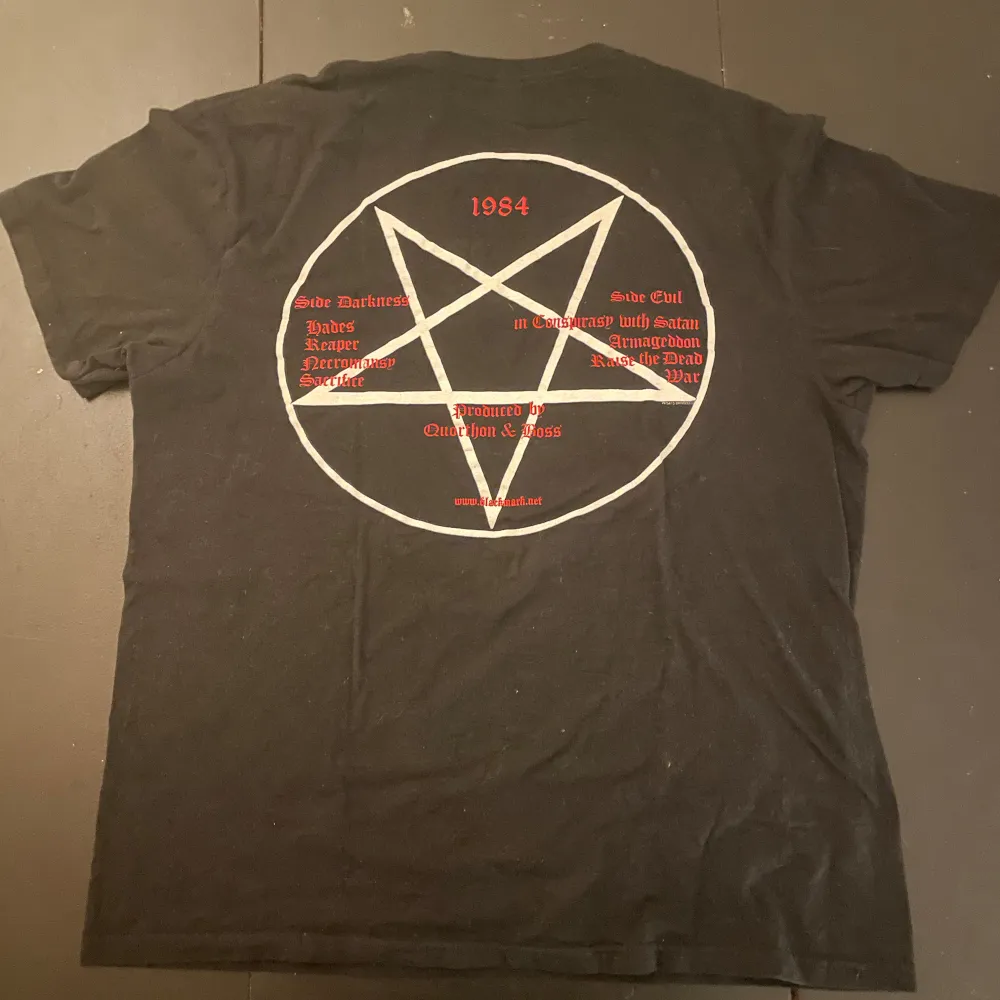 Säljer en svart t-shirt från Gildan med Bathory-tryck. Den har ett coolt getmotiv på framsidan och en pentagramdesign med texten '1984' på baksidan. Perfekt för dig som gillar metal och vill ha en unik stil. T-shirten är i bomull och har korta ärmar.. T-shirts.