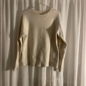 Beige stickad tröja från Vero Moda - Säljer en supermysig beige stickad tröja från Vero Moda. Tröjan har långa ärmar och en klassisk rund halsringning. Passar perfekt till både jeans och kjol för en avslappnad look. Nopprig men inga andra skador som t.ex hål.