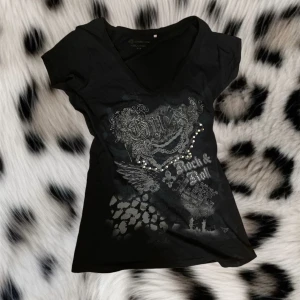 Svart t-shirt från Guess - Super fin svart t-shirt från Guess❤️med coolt tryck på framsidan<3( den är M men sitter med kroppen på mig some S-xs)