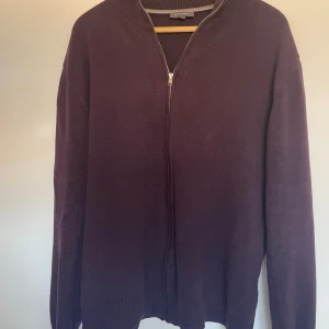 Mörklila kofta från Atlant - Säljer en snygg mörklila kofta från Atlant. Den har en dragkedja framtill och är perfekt för både höst och vinter. Koftan är långärmad och har en normal passform. Perfekt för att hålla sig varm och stilren!