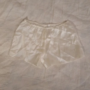 Vita siden shorts - Säljer ett par supermjuka och glansiga vita shorts i siden från intimissimi. De har en elastisk midja för en skön passform. 💕