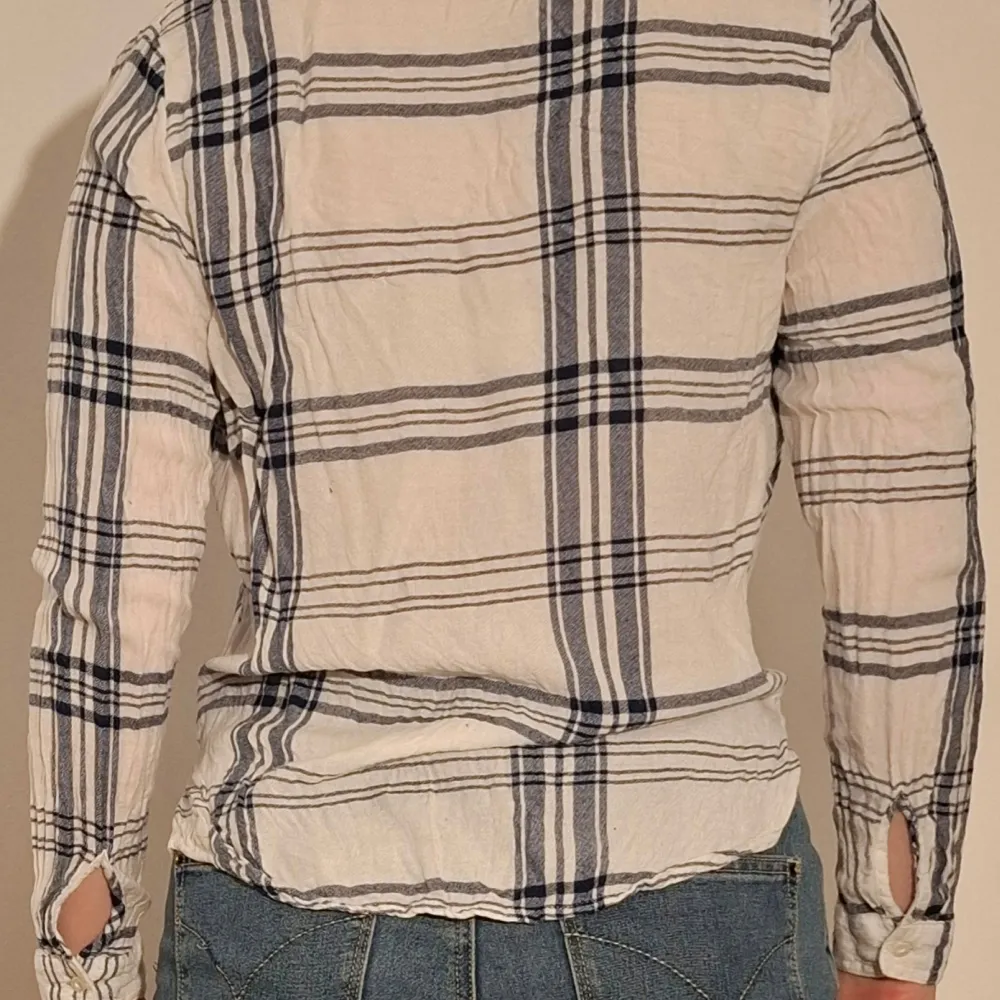 Blårutig blus med omlottdetalj. (Sista bilden visar tröjans material). Puserot.