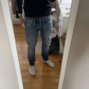 Säljer ett par snygga blå jeansbyxor i slim fit. De har en klassisk femficksdesign och en lätt tvättad look som ger en cool, avslappnad stil. Perfekta för både vardag och fest! Vill tillägga att framfickorna är paj därav priset