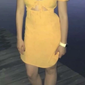 Orange klänning från Divided - Fin orange klänning med två roster fram till