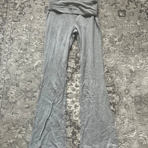 Grå byxor från Gina Tricot - Snygga grå byxor från Gina Tricot i en mjuk och bekväm stil. Byxorna har en hög midja och en bootcut design som ger en trendig look. Perfekta för en avslappnad dag.