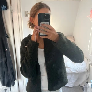 Mörkgrön teddyjacka från Aimn - Säljer en mysig mörkgrön teddyjacka från Urban Classics. Jackan har en dragkedja framtill och långa ärmar. Perfekt för kyligare dagar men även nu till våren. Skriv privat om ni har några andra frågor!