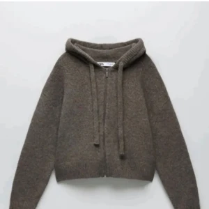 Brun stickad hoodie med dragkedja - Säljer en mysig brun stickad hoodie med dragkedja och huva. Perfekt för kyliga dagar med sin varma och bekväma design. Den har långa ärmar och ribbade kanter för extra komfort.