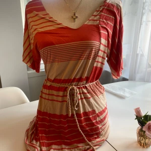 Orange röd klänning - En randig Flippa K avslappnande klänning med ett snöre som går att ta av om önskat. Perfekt sommar /vår klänning som man kan ha hemma och i vardagen🩷inga defekter.