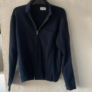 Mörkblå tröja med dragkedja/// overshirt med dragkedja.  - Säljer en stilren mörkblå tröja från Studio Total med dragkedja framtill och en bröstficka. Tröjan har en klassisk krage och långa ärmar. Är en overshirt med dragkedja. Riktigt snygg till våren. 