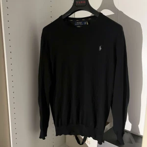 Svart tröja från Ralph Lauren - Säljer en stilren svart tröja från Ralph Lauren i slim fit. Tröjan är tillverkad av mjuk pima bomull och har en diskret logga på bröstet. Perfekt för en klassisk look.skick 10/10 knappt andvänd‼️