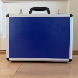 Blå verktygsväska från Toolcraft - Säljer en robust blå verktygsväska från Toolcraft. Perfekt förvarings- och transporthjälpmedel. Särskilt lämpad för ömtåliga föremål som cd-skivor, foton etc. Den invändiga skumbeklädnaden ger säker transport. Med två låsbara bygellås samt förstärkta kanter och hörn. Mått (L • B • H): 32 • 23 • 15 cm * Maximal bärförmåga: 5 kg * Låsbara bygellås  * Förstärkta hörn och kanter  * Skumbeklädnad * Väska,  * 2 nycklar 