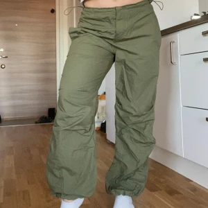 Gröna byxor med dragsko - Snygga gröna byxor med dragsko i midjan och vid bensluten. Byxorna har en loose passform och är perfekta för en avslappnad stil. De har också praktiska fickor både fram och bak.