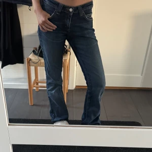 Mörkblå jeans från Lee - Snygga mörkblå jeans från Lee med låg midja och klassisk femficksdesign. Jeansen har en bootcut passform och är perfekta för en avslappnad stil. De har en knapp och dragkedja framtill. Säljer dessa för dem tyvärr var för långa och stora för mig som är 162💖Priset  kan diskuteras🫶