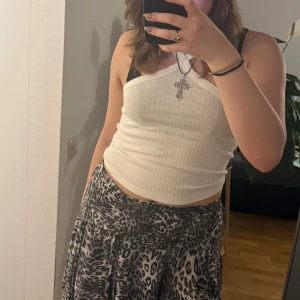 Vit ribbad linnetopp från Gina Tricot - Säljer en stilren vit ribbad linnetopp från Gina Tricot. Toppen har smala axelband och en enkel design som passar perfekt till sommaren. Perfekt för en avslappnad och trendig look.