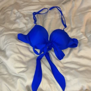 Blå bikini med knytband - Snygg blå bikini med knytband framtill. Den har vadderade kupor och justerbara axelband för perfekt passform. Perfekt för en dag på stranden eller vid poolen. 💙