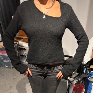 Svart stickad tröja - Säljer en stilren svart stickad tröja med lång ärm och unik asymmetrisk halsringning. Perfekt för kyligare dagar och enkel att matcha med olika outfits❤️❤️