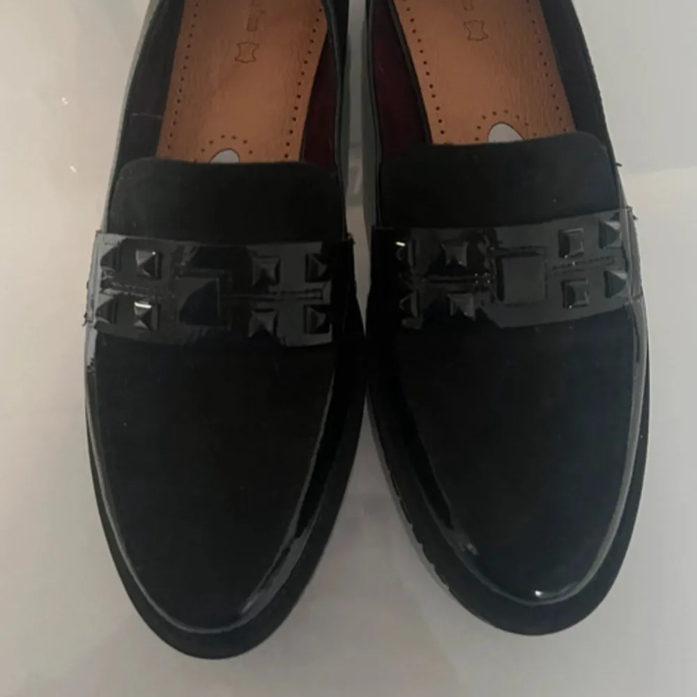 Snygga svarta loafers i lack med dekorativa nitar på ovansidan. De har en extrasula i min den kan tas bort då den int är limmad eller liknande. Anväda en gång. Kengät.