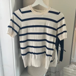 Finstickad T-shirt  - Säljer en randig tröja från Zara i vitt och marinblått. Använd men inga tecken på det. Är i storleken s men skulle mer säga att den passar som xs