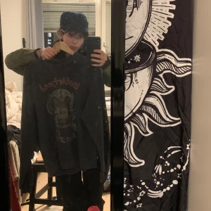 Mörkgrå Motörhead Tröja - Säljer en svart långärmad tröja med Motörhead-tryck på framsidan och turnélista från Iron Fist Tour 1982 på baksidan. Perfekt för rockälskare! Tröjan har en rund halsringning och är i en bekväm passform.