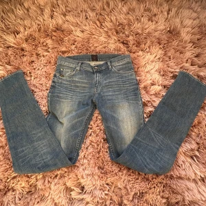 Blå jeans från Tiger of Sweden - Snygga blå jeans från Tiger of Sweden med klassisk femficksdesign. De har en slim passform och är tillverkade i slitstarkt denim. Perfekta för en stilren look. Kom privat för frågor eller fler bilder.
