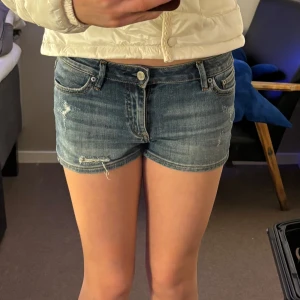Jeansshorts från Crocker - Snygga jeansshorts från Crocker i en klassisk blå färg. De har en lågmidjad design med slitna detaljer för en trendig look. Perfekta för sommardagar och avslappnade tillfällen.