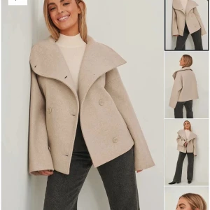 Beige kappa från NA-KD - Snygg beige kappa från NA-KD med stora knappar och en elegant krage. Perfekt för kyligare dagar med sin stilrena design och långa ärmar. Passar utmärkt till både jeans och klänning.