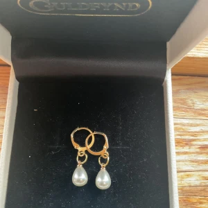 Pearl drop - Eleganta guldörhängen från som är hemgjorda med hängande vita pärlor. Perfekta för att ge en klassisk touch till din stil. 