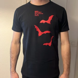 Svart t-shirt med rött tryck från Off-White - Säljer en svart t-shirt från Off-White  perfekt för en stilren look. T-shirten har korta ärmar och rund halsringning. Hör av er om ni har frågor
